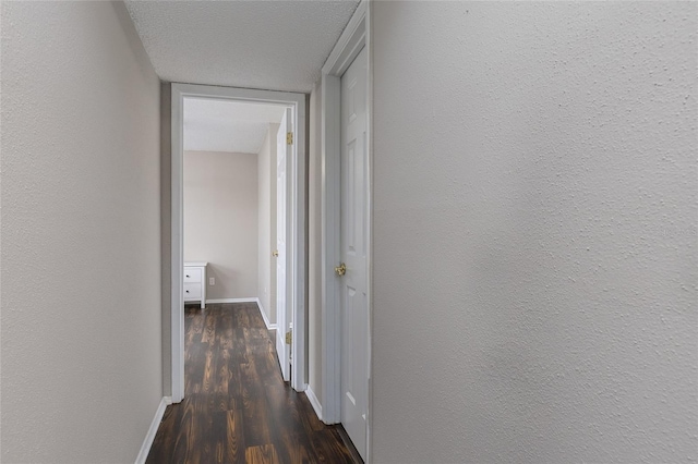 hall featuring dark hardwood / wood-style floors and a textured ceiling