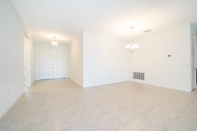 unfurnished room featuring an inviting chandelier