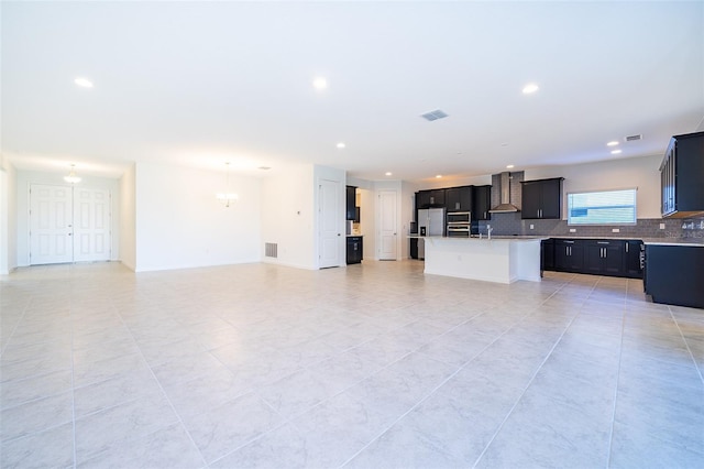 unfurnished living room featuring sink, light tile patterned floors, and a notable chandelier