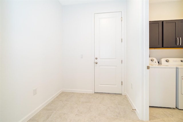 clothes washing area with cabinets, light tile patterned floors, and washer and clothes dryer