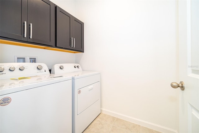 laundry area featuring cabinets, light tile patterned flooring, and washing machine and clothes dryer