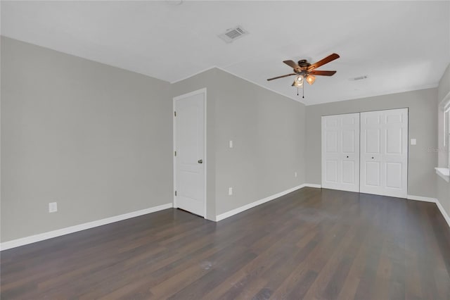 unfurnished bedroom with dark hardwood / wood-style flooring, a closet, and ceiling fan