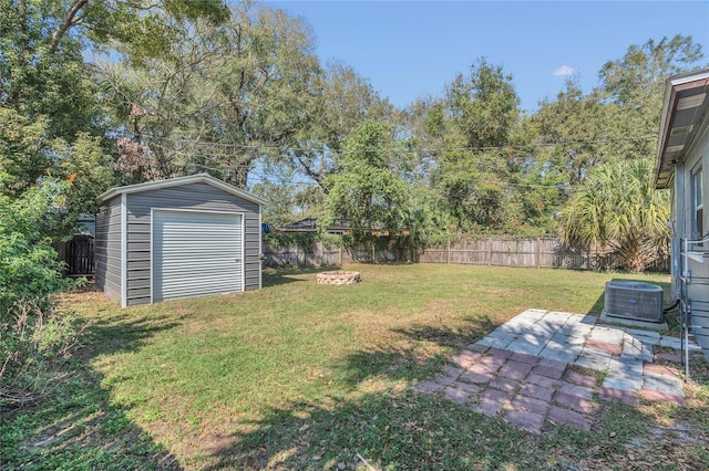 view of yard with a fire pit, central air condition unit, and a storage unit