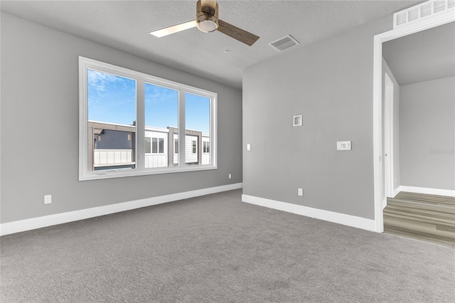 carpeted empty room with a textured ceiling and ceiling fan