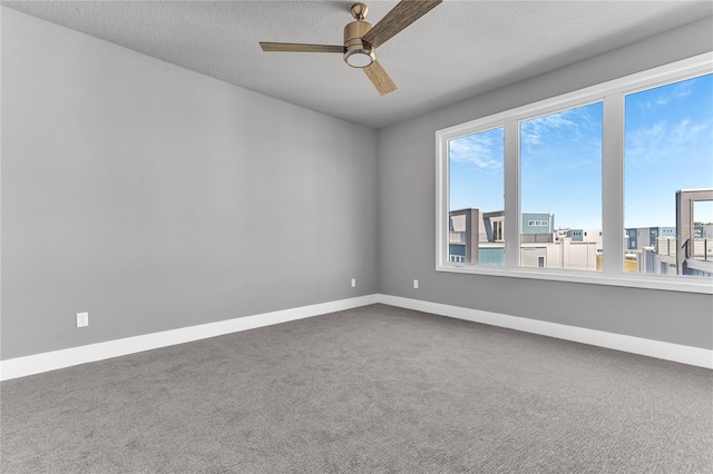 unfurnished room featuring ceiling fan, carpet floors, and a textured ceiling