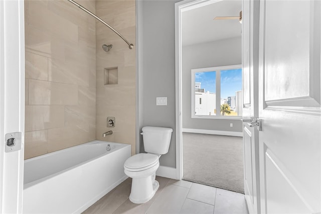 bathroom featuring toilet, tiled shower / bath combo, and tile patterned flooring