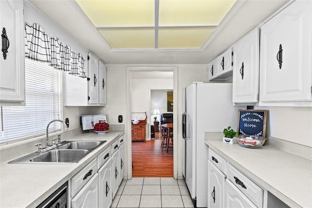 kitchen with sink, dishwasher, white cabinetry, white fridge with ice dispenser, and light tile patterned flooring