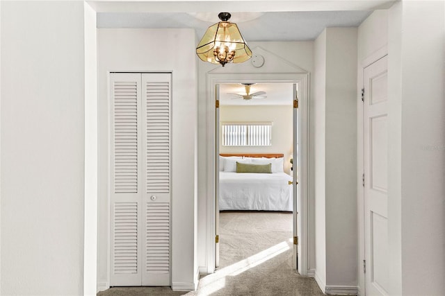 hallway featuring a chandelier and carpet floors