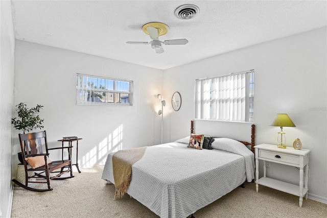 carpeted bedroom with ceiling fan and multiple windows