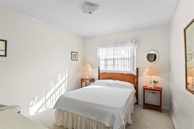 bedroom featuring light carpet and a textured ceiling