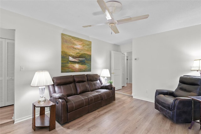 living area with baseboards, ceiling fan, and wood finished floors