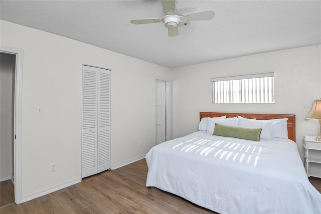 bedroom with baseboards, a ceiling fan, a closet, and wood finished floors