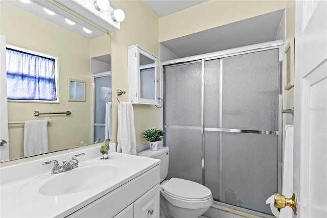 bathroom with vanity, a shower stall, and toilet
