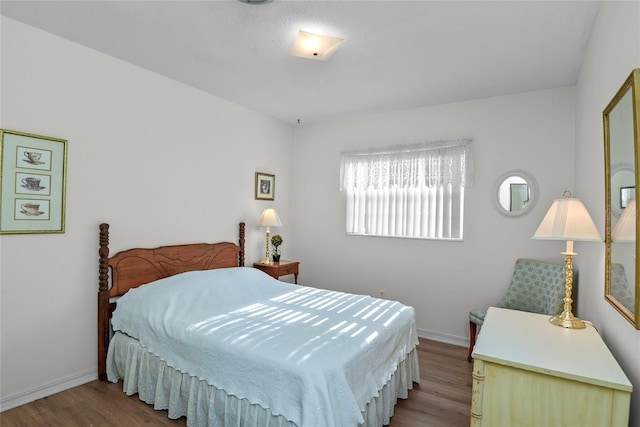 bedroom featuring baseboards and wood finished floors