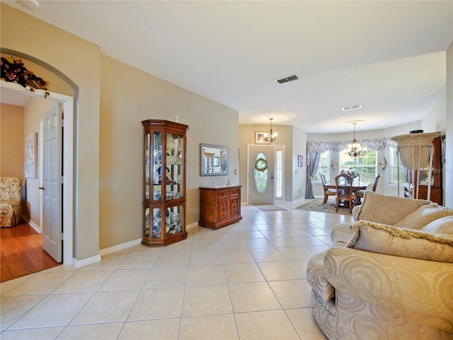 tiled living room featuring a notable chandelier