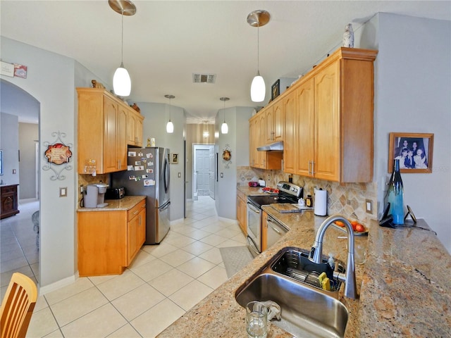 kitchen featuring sink, appliances with stainless steel finishes, backsplash, hanging light fixtures, and light stone counters