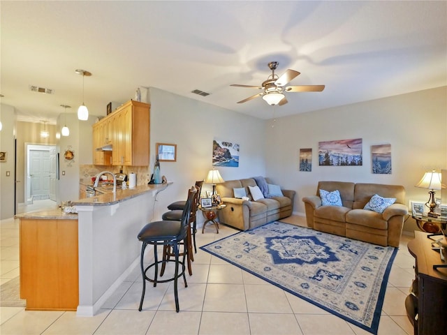 living room with light tile patterned floors, sink, and ceiling fan