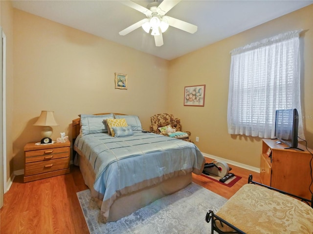 bedroom featuring multiple windows, ceiling fan, and light hardwood / wood-style flooring