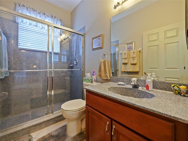 bathroom featuring tile patterned floors, vanity, toilet, and a shower with shower door