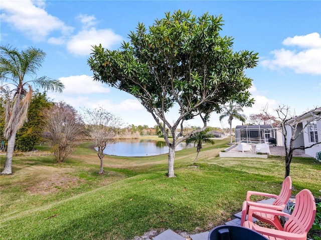 view of yard with a water view and a lanai