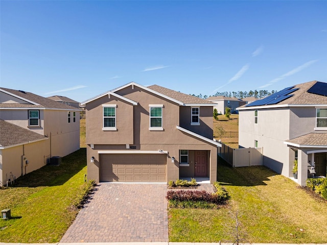 view of front of house with a garage, central AC, and a front yard