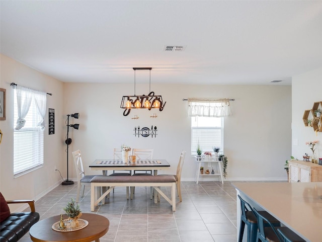 dining space featuring plenty of natural light, light tile patterned floors, and a notable chandelier