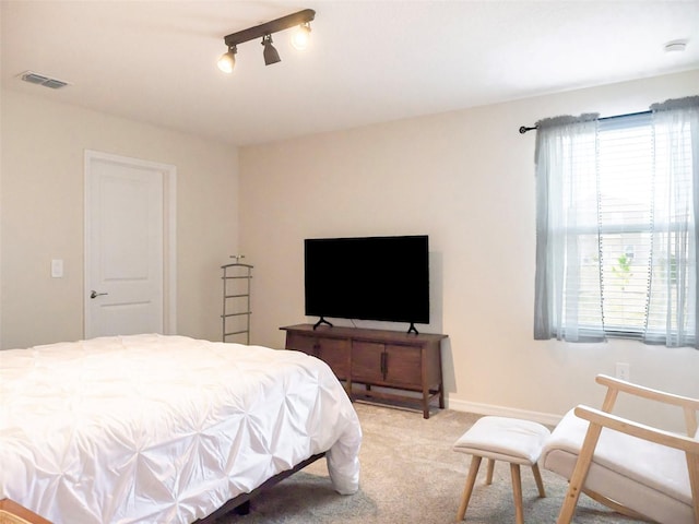 carpeted bedroom featuring track lighting