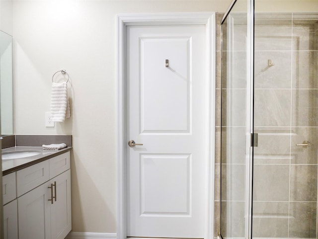 bathroom featuring vanity and a shower with door