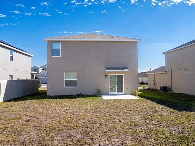 back of house with central AC unit, a patio area, and a lawn