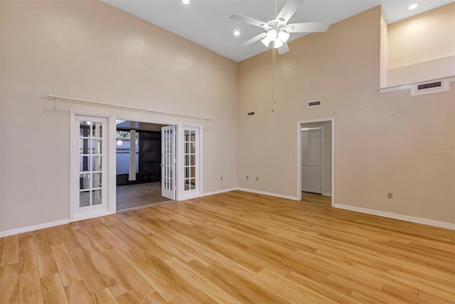 unfurnished living room featuring ceiling fan, light hardwood / wood-style floors, high vaulted ceiling, and french doors