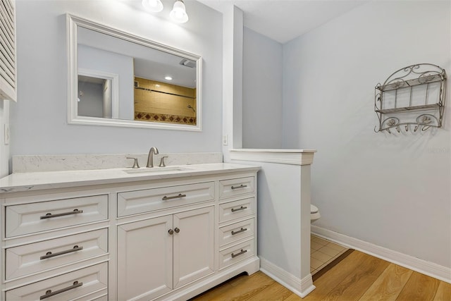 bathroom featuring vanity, hardwood / wood-style floors, toilet, and walk in shower