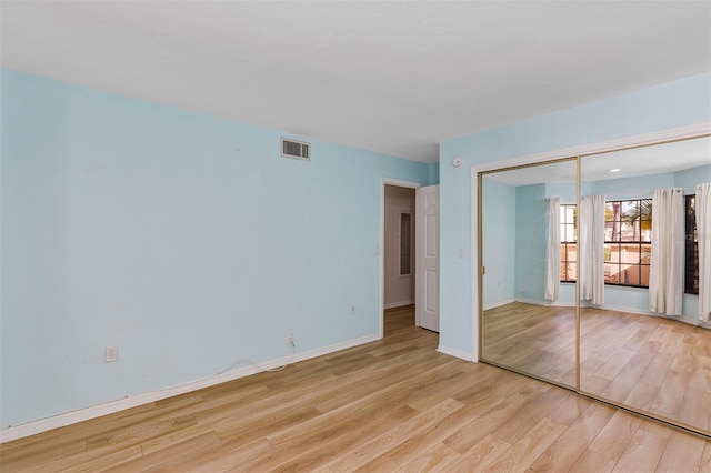 unfurnished bedroom with a closet and light hardwood / wood-style flooring