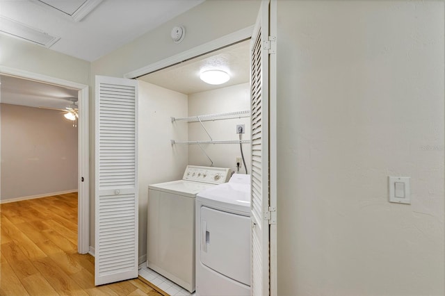 clothes washing area featuring light hardwood / wood-style flooring and washer and dryer