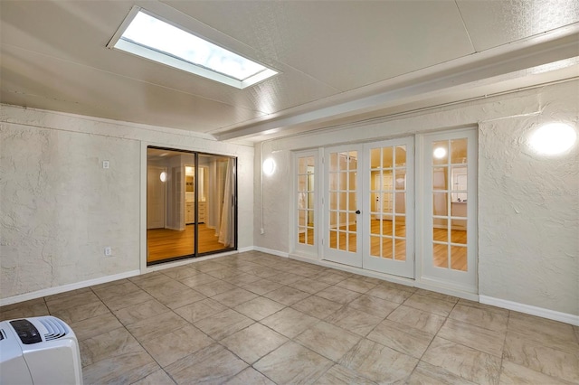 empty room featuring a skylight and french doors