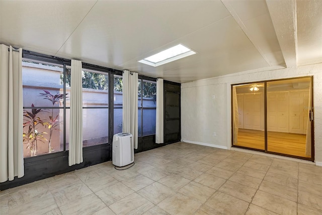 unfurnished sunroom featuring a skylight