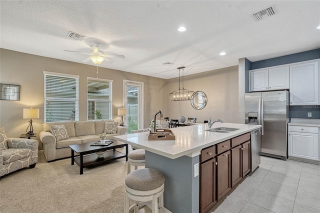 kitchen featuring white cabinetry, appliances with stainless steel finishes, decorative light fixtures, and sink