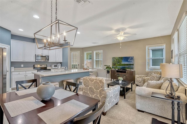 dining space with ceiling fan and sink