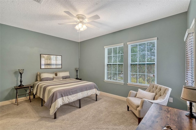 carpeted bedroom featuring ceiling fan and a textured ceiling