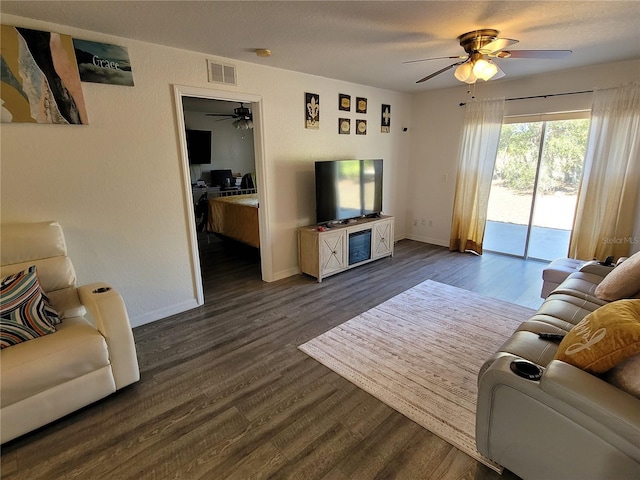 living room featuring ceiling fan and dark hardwood / wood-style floors