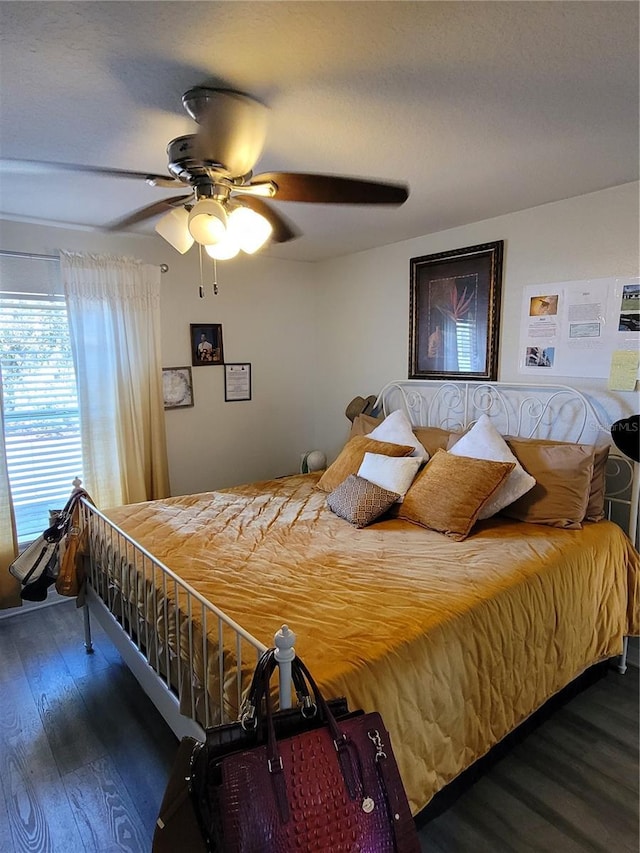 bedroom with dark hardwood / wood-style floors and ceiling fan