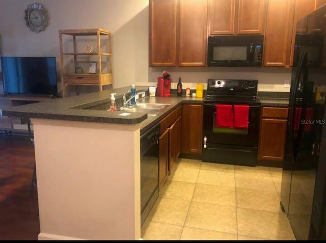 kitchen with sink, black appliances, kitchen peninsula, and light tile patterned flooring