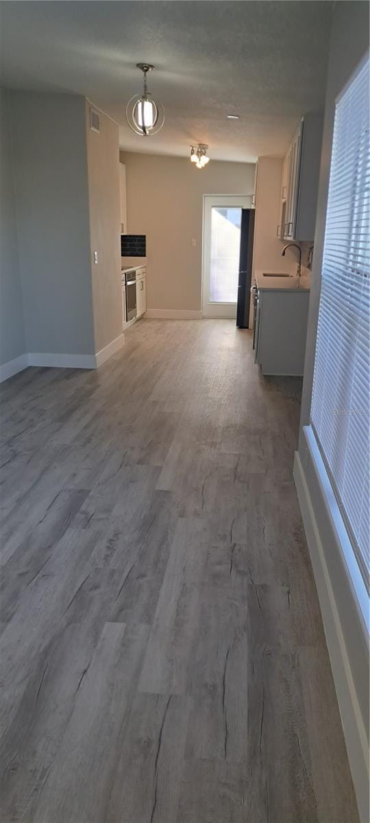 unfurnished living room featuring sink and hardwood / wood-style floors