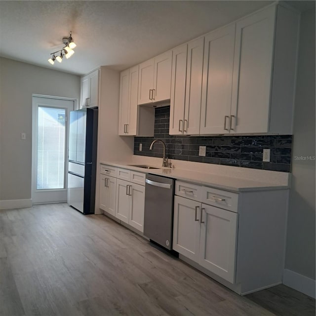 kitchen featuring dishwasher, sink, white cabinets, and refrigerator