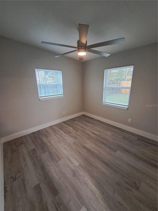 spare room with hardwood / wood-style flooring, a wealth of natural light, and ceiling fan