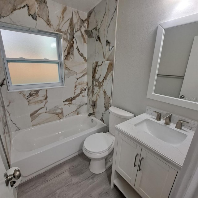 full bathroom featuring vanity, tiled shower / bath combo, wood-type flooring, and toilet