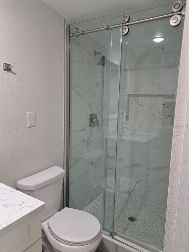 bathroom with vanity, an enclosed shower, and toilet