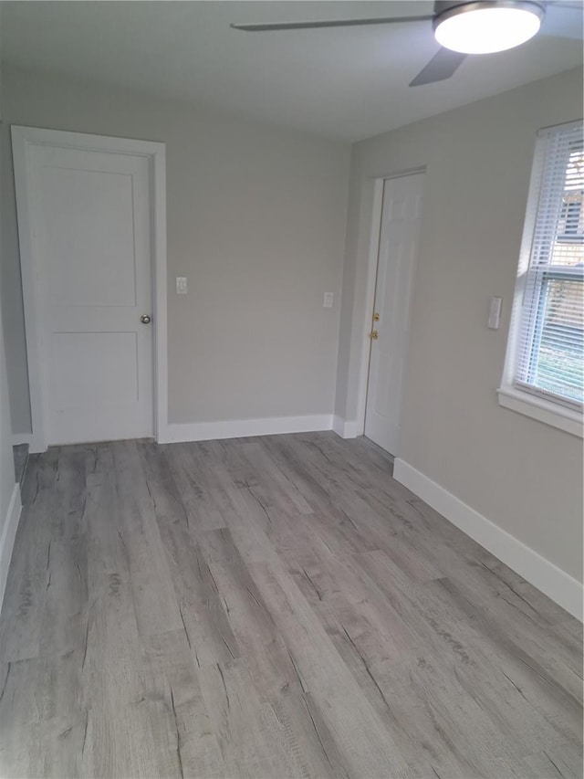 spare room with ceiling fan and light wood-type flooring