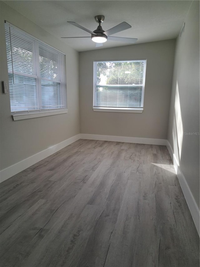 empty room with hardwood / wood-style floors and ceiling fan