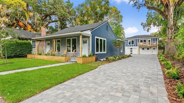 view of front facade with a garage, covered porch, and a front yard