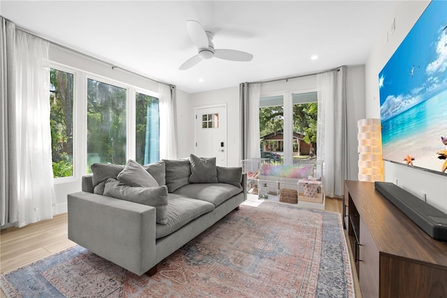 living room with ceiling fan, light hardwood / wood-style flooring, and a healthy amount of sunlight